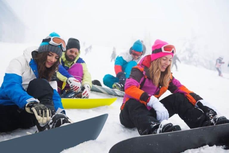 Two couples having fun snowboarding